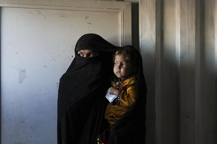 An Afghan woman waits in the makeshift clinic organized by World Vision at a settlement near Herat, Afghanistan.