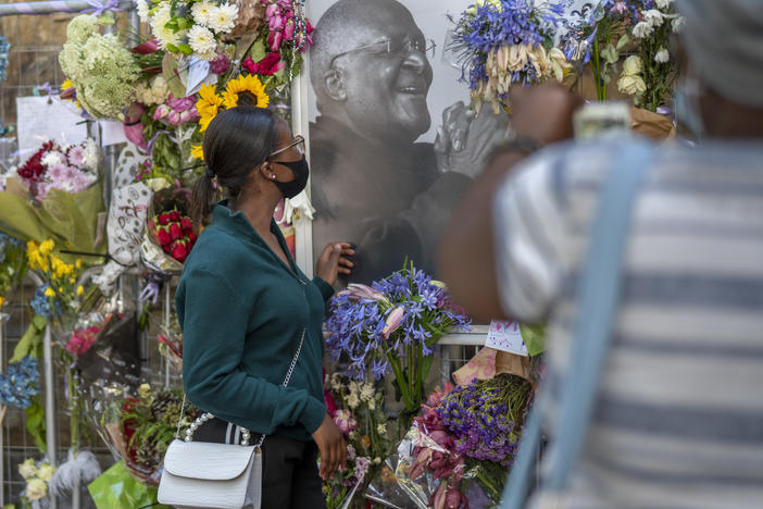 People read cards left with flowers in memory of Anglican Archbishop Emeritus Desmond Tutu at the St. George's Cathedral.