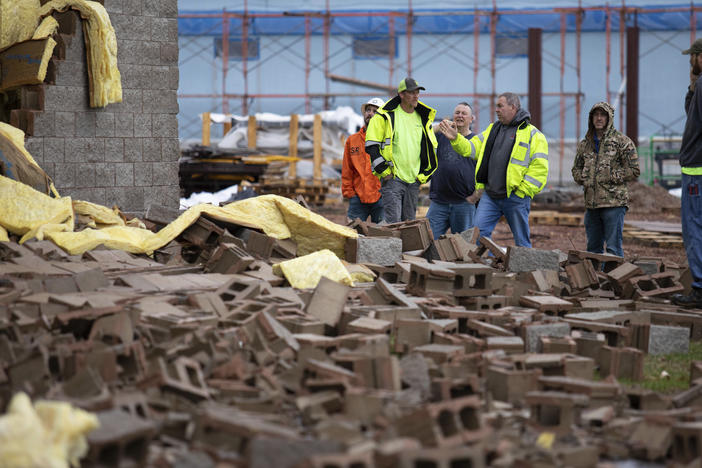 Utility workers and city crews survey and help clear debris at Thornton Furniture in Bowling Green, Ky., after a tornado warning was issued on Saturday for Warren and surrounding counties.
