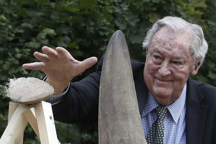 Richard Leakey, Kenyan wildlife conservationist, places a rhino horn to be burned at the zoo in Dvur Kralove, Czech Republic, in 2017. Leakey, known for his fossil-finding and conservation work in his native Kenya, has died at 77.