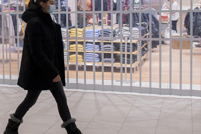 A woman walks by a closed store in a shopping mall in Montreal, Sunday as the COVID-19 pandemic continues in Canada. Some new measures put in place by the Quebec government, including the closure of stores, go into effect today.