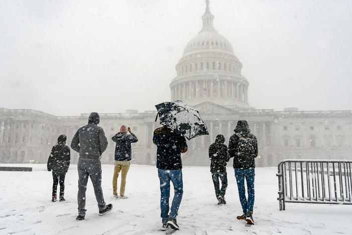 Visitors from France enjoy the scenery as a winter storm delivers heavy snow to the Capitol in Washington, D.C., on Monday.