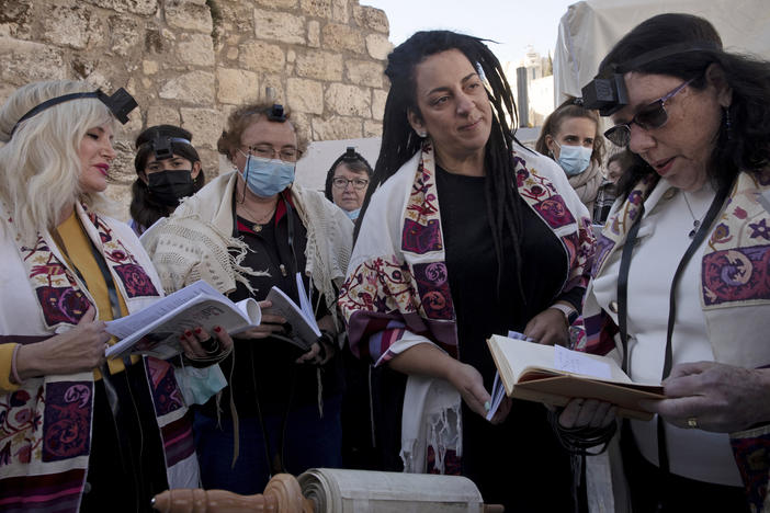 Members of Women of the Wall gather around a Torah scroll the group smuggled in for their Rosh Hodesh prayers marking the new month, at the Western Wall where women are forbidden from reading from the Tora.