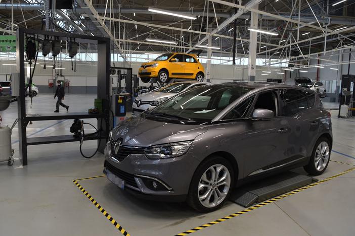 An employee walks among the cars during the inauguration of a factory that will recondition used cars near Paris, on Nov. 30.