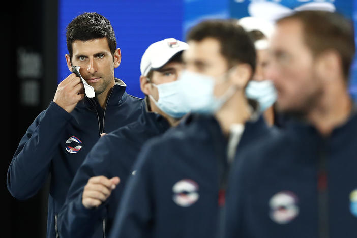 Novak Djokovic will play in the 2022 Australian Open, after getting an exemption from vaccine requirements. He's seen here removing his mask at the 2021 ATP Cup at Rod Laver Arena in Melbourne last February.