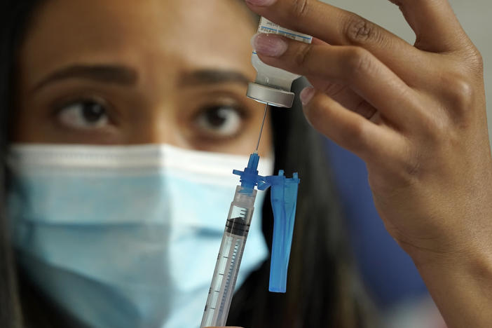 Licensed practical nurse Yokasta Castro, of Warwick, R.I., draws a Moderna COVID-19 vaccine into a syringe. The vaccines have now been linked to minor changes in menstruation, but are still considered safe.