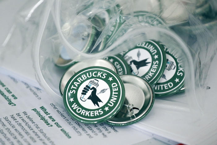 Pro-union pins sit on a table during a watch party for a Starbucks employees union election on Dec. 9 in Buffalo, N.Y.