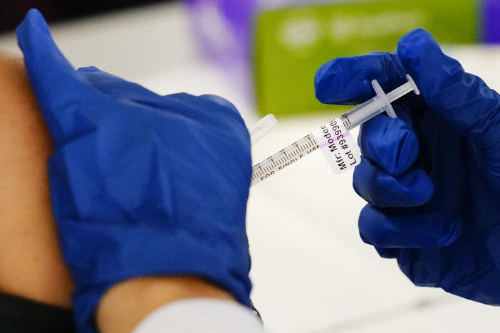 A health worker administers a dose of a Moderna COVID-19 vaccine during a vaccination clinic at the Norristown Public Health Center in Norristown, Pa., Tuesday, Dec. 7, 2021.