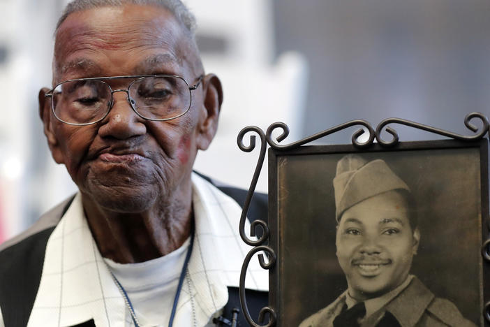 World War II veteran Lawrence Brooks, pictured holding a photo of himself as a soldier in 1943, died on Wednesday at age 112.