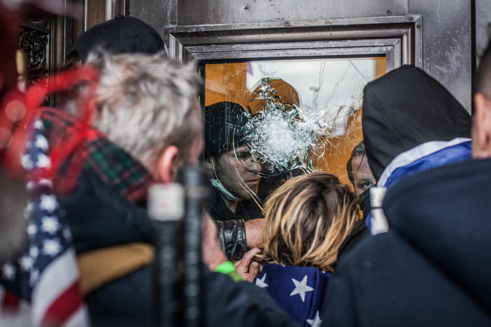 Capitol Police officers try to hold off the crowds from inside the U.S. Capitol on Jan. 6, 2021. At the end of the day, windows and doors were smashed, trash littered the building and several people were dead.