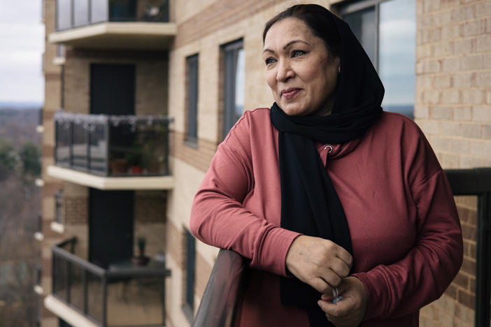 After several months of temporarily housing, Kamila Noori, a prominent Afghan judge, stands on the balcony of the apartment where she will live with her husband and two of their daughters.