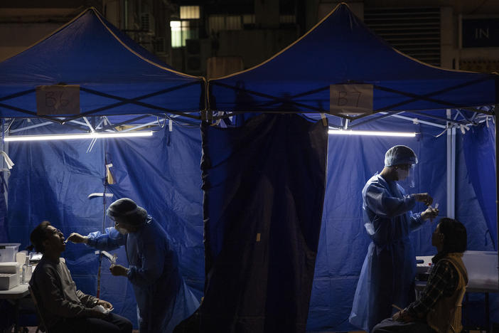 Health workers administer COVID tests outside a building placed under lockdown in Hong Kong on Jan. 6. Hong Kong is imposing strict new COVID measures for the first time in almost a year as the omicron variant seeps into the community.