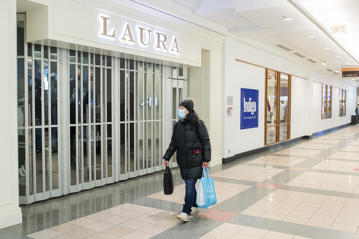 A woman walks by a closed store in a mall in Montreal on Jan. 2.