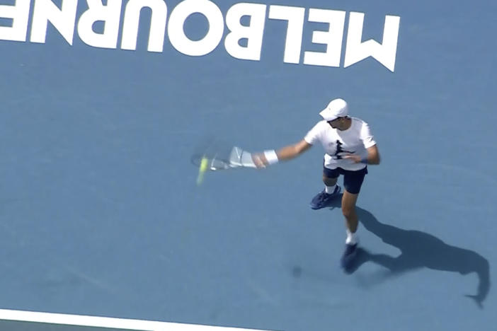 In this image taken from aerial video footage, tennis star Novak Djokovic practices on the tennis court on Tuesday in Melbourne, Australia.