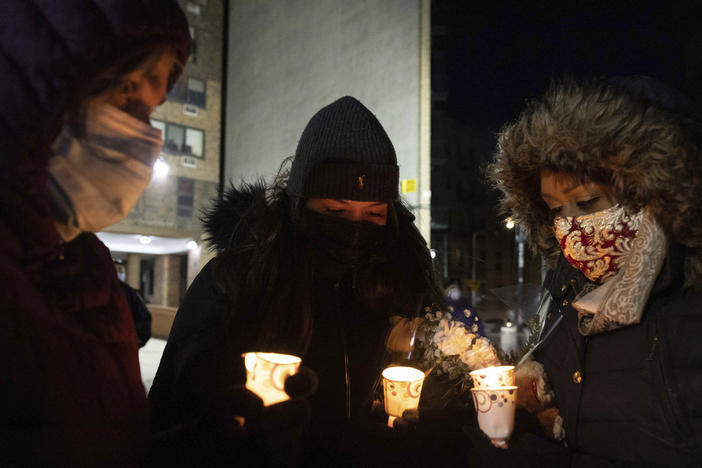 People gather Tuesday evening for a candlelight vigil outside the Bronx apartment building which was the scene of the city's deadliest fire in decades.