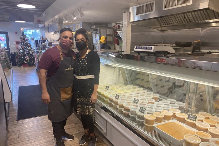 Juby George stands with his wife Shireen Bethala-George at the soft opening of Smell the Curry, a south Indian takeout and catering business at the Flourtown Farmers Market outside Philadelphia, on December 9, 2021.