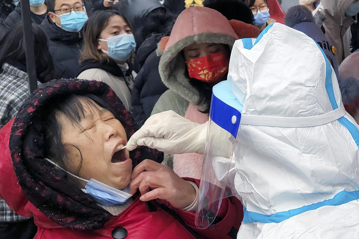 A medical worker takes swab samples on residents in central China's Henan province. The northern city of Tianjin ordered a second round of testing on all 14 million residents Wednesday.