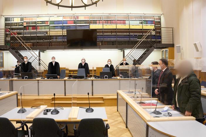 Defendant Anwar Raslan (right) and others involved in his trial stand in the Higher Regional Court in Koblenz, Germany, at the start of a trial session last month. Raslan was put on trial in April 2020 in a landmark case in Germany.