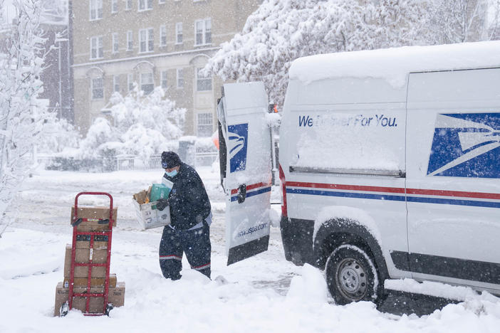A postal worker carries packages through the snow on Jan. 3 in Washington, D.C.