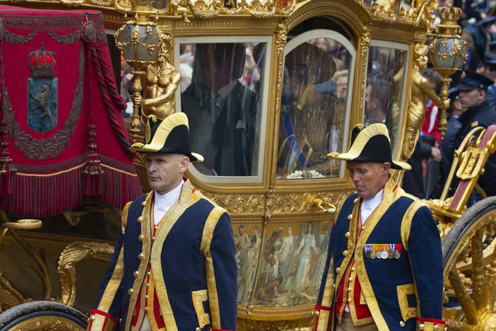 Footmen walk alongside the Golden Carriage as Netherlands' King Willem-Alexander and Queen Maxima arrive at Noordeinde Palace on Sept. 17, 2013.