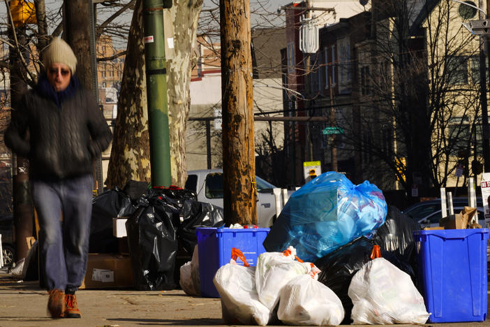 Trash sits out for collection on a Philadelphia street on Thursday. The omicron variant is sickening so many sanitation workers that waste collection in Philadelphia and other cities has been delayed or suspended.