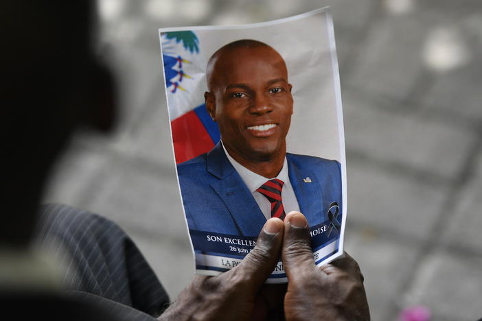 A person holds a photo of late Haitian President Jovenel Moïse during his memorial ceremony in Port-au-Prince, Haiti, on July 20, 2021.