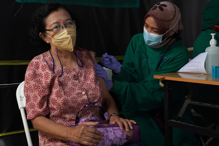 A resident receives a dose of the Pfizer COVID-19 vaccine at a health center in Jakarta, Indonesia, on Jan. 13. This week, Indonesia started a program to give booster shots to the elderly and people at risk of severe disease.