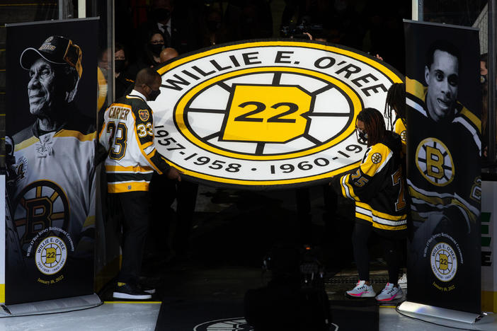 Anson Carter helps carry the banner for former Boston Bruins player Willie O'Ree, as the team retired his No. 22 jersey at the TD Garden Tuesday night.