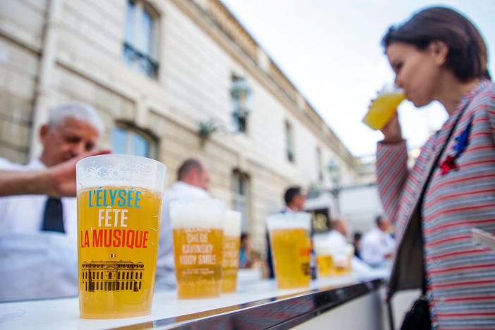 A woman drinks an alcohol-free beer during the annual "Fete de la Musique" (music day), in the courtyard of the Elysee Palace in Paris in 2018.