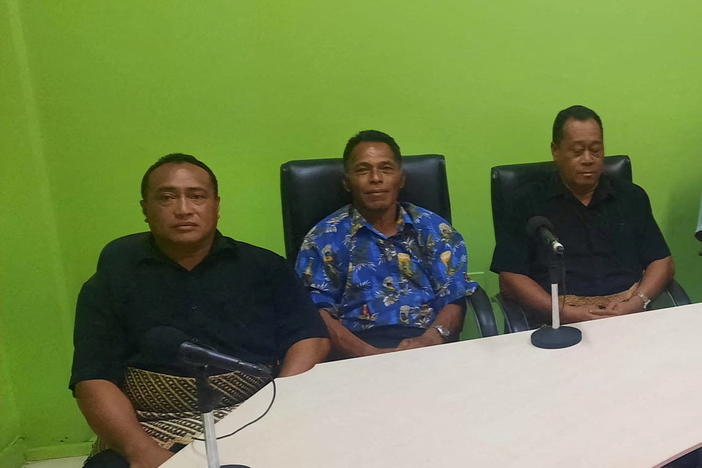 Lisala Folau (wearing blue printed shirt) says he swam for more than 24 hours after getting swept to sea by Saturday's tsunami, sits with other people of Atata island in Nuku'alofa, Tonga, on Wednesday in this picture obtained from social media.