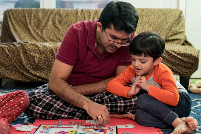 Dhaval Bhatt plays Monopoly with his children, Hridaya (left) and Martand, at their home in St. Peters, Missouri. Martand's mother took him to a children's hospital in April after he burned his hand, and the bill for the emergency room visit was more than $1,000 — even though the child was never seen by a doctor.