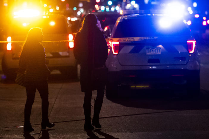 People walk past the Sol Tribe tattoo shop where two women were shot and killed and a man injured on Dec. 27 in Denver, Colo. It was the first in a series of shootings that claimed five lives across the area.