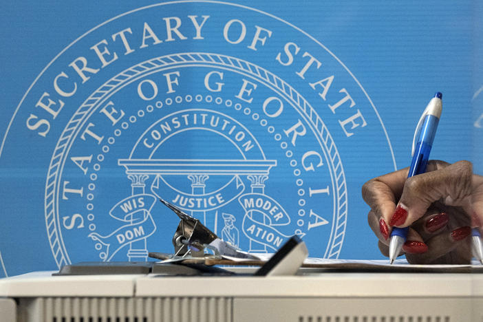 In this Dec. 14, 2020, file photo, a voter fills out paperwork before casting a ballot the first day of early voting for the Senate runoff election in Atlanta.