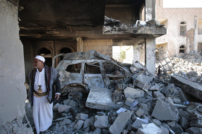 A man inspects the wreckage of a building after it was damaged in Saudi-led coalition airstrikes, in Sanaa, Yemen, Tuesday, Jan. 18, 2022.