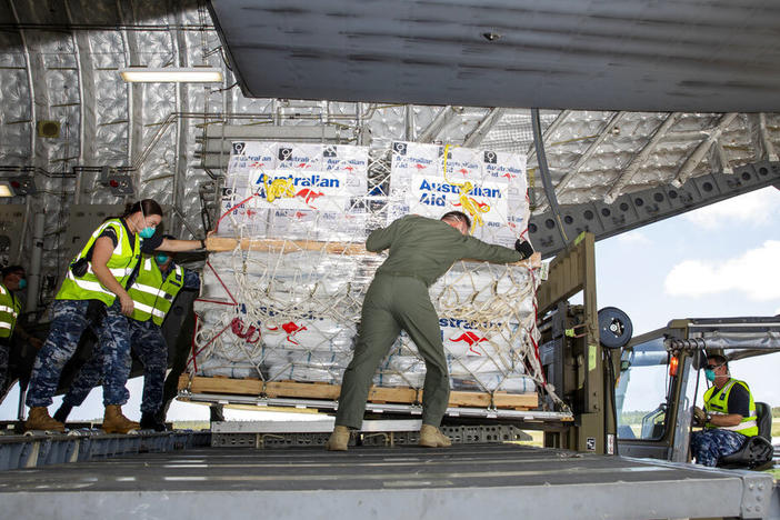 In this photo provided by the Australian Defence Force, personnel unload emergency aid supplies at Tonga's Fuaʻamotu International Airport, near Nukuʻalofa, Thursday, Jan. 20, 2022, after a volcano eruption.