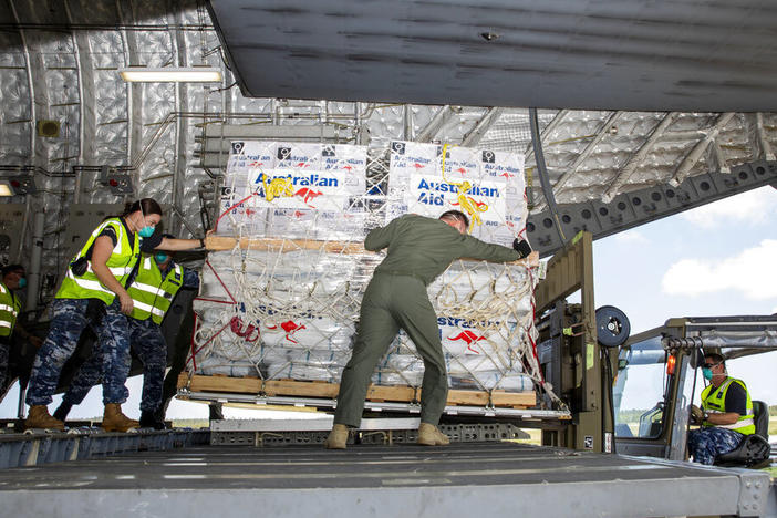 In this photo provided by the Australian Defence Force, personnel unload emergency aid supplies at Tonga's Fuaʻamotu International Airport, near Nukuʻalofa, Thursday, Jan. 20, 2022, after a volcano eruption.