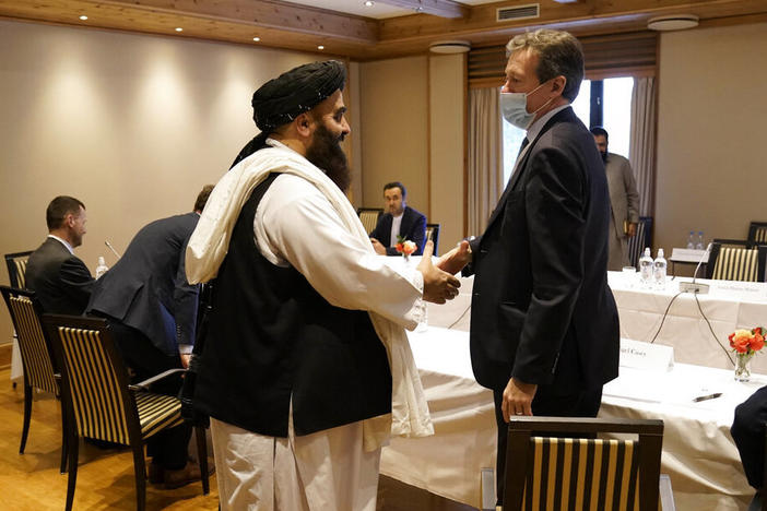 Special Representative for Afghanistan Nigel Casey, right, shakes hands with Taliban representative Amir Khan Muttaqi, center, ahead of a meeting in Oslo, Norway, Monday.