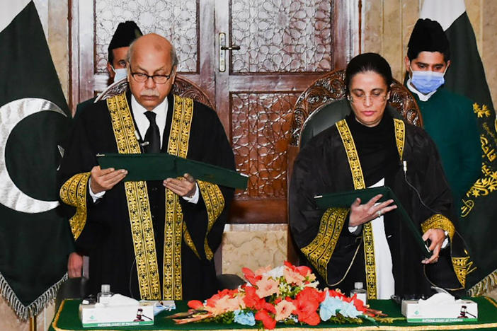 In this photo provided by Pakistan's Press Information Department, Pakistan's Chief Justice Gulzar Ahmad, left, administrates the oath of office to Ayesha Malik in Islamabad, Pakistan on Monday. Malik is the first female judge to serve on Pakistan's Supreme Court.