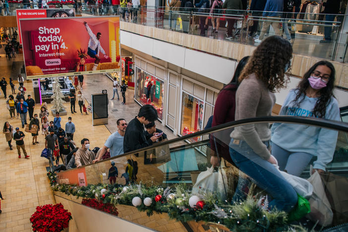 People shop in The Galleria mall in Houston during Black Friday on Nov. 26, 2021. The economy grew strongly last year but at an uneven pace because of the pandemic.
