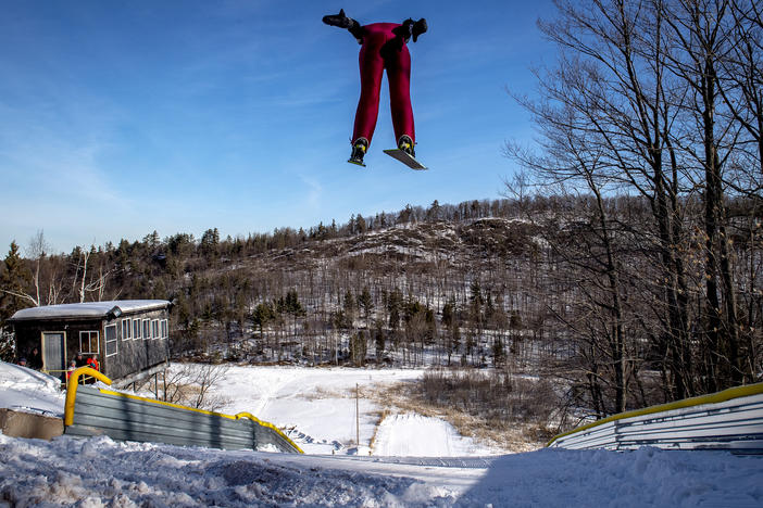 A ski jumper flies overhead on the 60-meter ski jump at the Suicide Hill Ski Bowl in Ishpeming, Mich. on March 7, 2021. The Suicide Hill Ski Bowl is home to 5 ski jumps - one being the infamous 90-meter Suicide Hill Ski Jump.