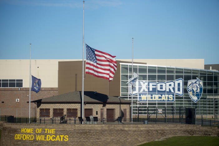 The American flag flies at half-staff on Dec. 2, 2021, outside of Oxford High School in Oxford, Mich.