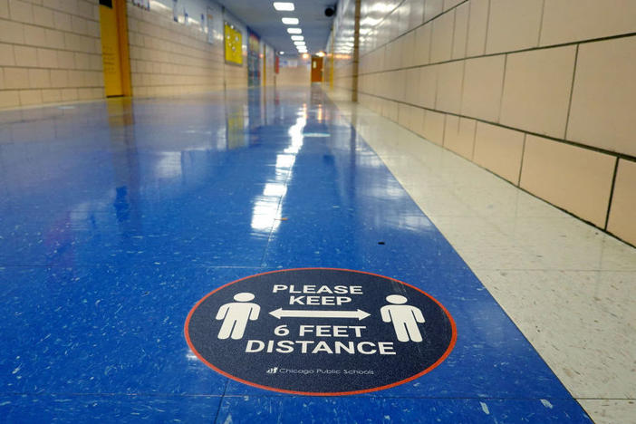 A sign in a hallway at a Chicago elementary school reinforces the mantra of social distancing.