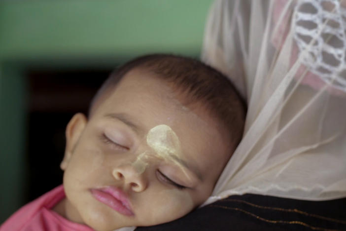 A scene from <em>Midwives</em>: A baby whose face is adorned with thanaka — a kind of sunscreen made from wood bark.