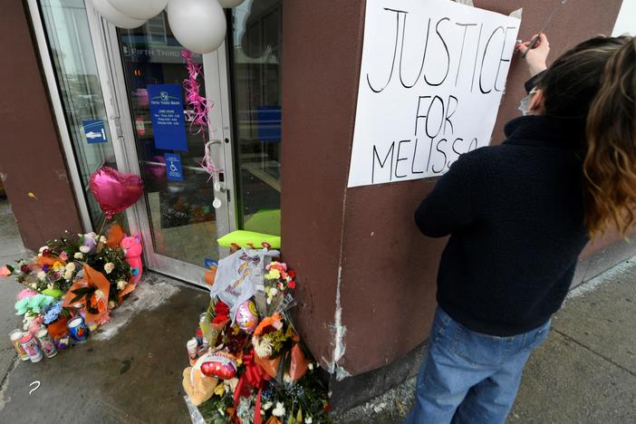Karla Chavez, of the social activist group Chiactivists, puts up a sign at a memorial for 8-year-old Melissa Ortega in Chicago on Jan, 24. Ortega was walking with her mother in Chicago's Little Village neighborhood on Jan. 22 when she was struck by stray bullets after an unknown offender shot multiple times in their direction.