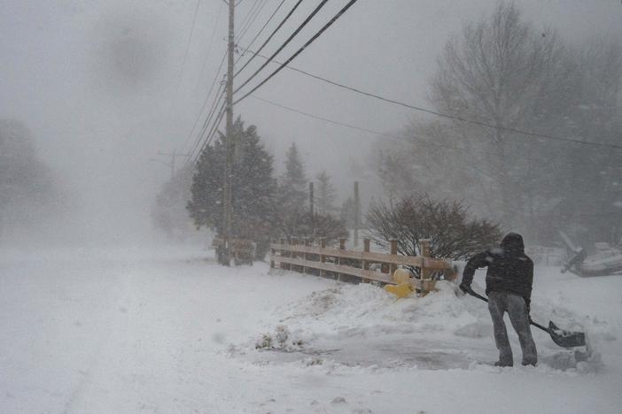 A man shovels snow in near whiteout conditions during a nor'easter in Marshfield, Mass., on Saturday.