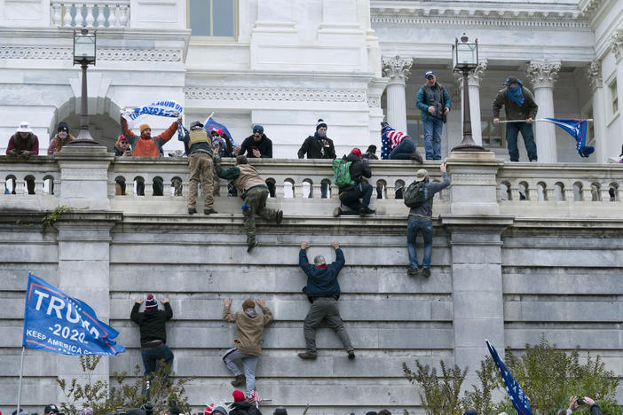 Trump supporters climb the west wall of the U.S. Capitol on Jan. 6, 2021. A new survey finds 1 in 10 Americans say violent protests are justified.