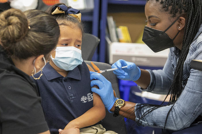 Sandra Castro vaccinates first-grader Kristen Cruz, 6, at KIPP Believe Charter School in New Orleans last week ahead of Tuesday's deadline for all students in the city's school system to be vaccinated.