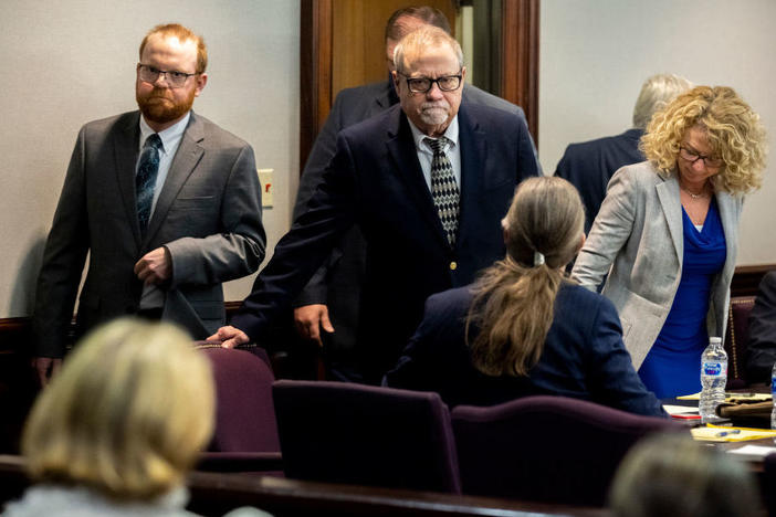 Greg McMichael (center) and his son Travis McMichael (left) look at family members seated in the gallery when they walk into the courtroom for the reading of the jury's verdict for themselves and a neighbor, William "Roddie" Bryan, in the Glynn County Courthouse on Nov. 24, 2021, in Brunswick, Ga. The three men were charged with the fatal shooting of 25-year-old Ahmaud Arbery in 2020.