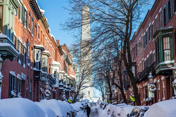 A person shovels out homes and cars near the Bunker Hill Monument in Boston, Mass., on Sunday. Blinding snow whipped up by powerful winds pummeled the eastern United States into the early hours Sunday as one of the strongest winter storms in years triggered transport chaos and power outages across a region of some 70 million people.
