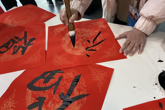 At the Main Media Center, the central hub for press, volunteers offered passersby the opportunity to paint calligraphy onto traditional New Year couplets.